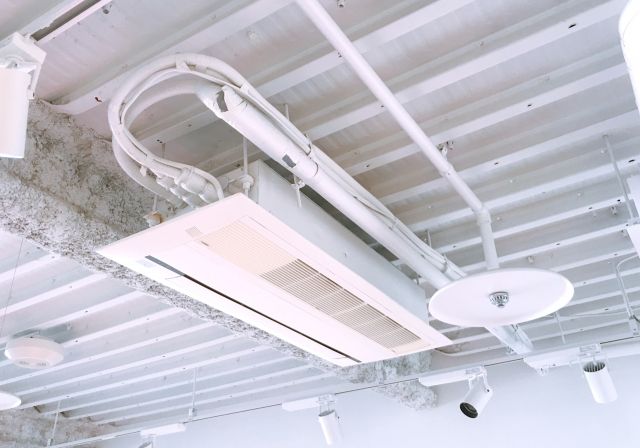 業務用エアコンのリモコンを操作する手