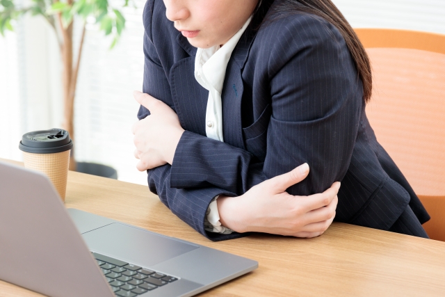 業務用エアコンの風が直接あたり寒さを感じる女性